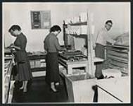 [Two women and a man in the printing office, Regina, Saskatchewan, 1950s] ca. 1950