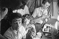 Three clowns apply makeup backstage 1956