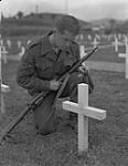 Un militaire devant la tombe d'un soldat 1957