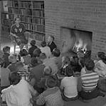 Children gathered around a librarian 1958