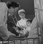 Dr. Ghislaine Gilbert and nurse Pierrette Giffard visiting the children's ward at the Montreal Institute of Cardiology Nov. 1958