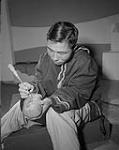 An Inuit man working on a stone carving 1959