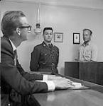 Jack White, assis, et le constable Newcombe, en procès dans l'une des plus petites salles d'audience au Canada 1960