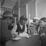 Henry Anatuk, co-operative manager, taking Inuit woman's order Aug. 1960