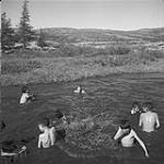 Inuit children swimming in a swimming hole Aug. 1960