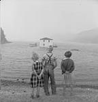 La maison de M. Malcolm Rogers amarrée au rivage en attendant la marée haute, dans le cadre d'une relocalisation de l'île Fox vers l'île Flat août 1961
