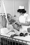 A nurse playing with a young patient 1961