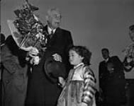Prime Minister St. Laurent receiving bouquet from Korean civilian at K-16 airport in Korea March 1954.