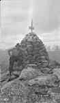 A member of Cautely's crew at cairn at top of pass. Alberta-BC boundary suvrey 1921