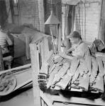 L'ouvrier Eddie Jenkins utilise une ponceuse automatique pour polir la monture d'un fusil d'exercice de calibre .22 à la fabrique de munitions H.W. Cooey Co. Ltd May 1944