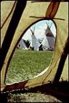 [Tipis and people seen through the doorway of a tipi] July 1972