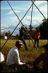 [Two individuals setting up a tipi] July 1972