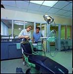[Woman demonstrating a dental procedure to a man] [between 1900-1976]