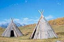 [Two tipis (teepees) made of wood]