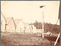 [Houses and monumental pole in the Tlingit community of Kake]. Original title: Indian houses, Kake, Alaska [between 1889-1942].