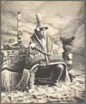 [Studio portrait of Chief Cow-Dik-Ney, Tlingit, in clothing worn for potlatch ceremony]. Original title: Old Chief Kow-Dik-Ney 1906