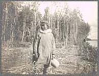 [Inuk man at Yukon River wearing parka and holding basket]. Original title: Yukon River Esquimo [between 1889-1942].