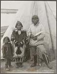 [Inuvialuit family at Peel's River. Man is holding a pana (snow knife)]. Original title: Esquimaux Peels River [ca. 1901]