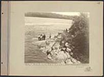 [Anishinaabeg men] putting out tow line at Rapids on Rainy River. Original title: Indians putting out tow line at Rapids on Rainy River [June 1899].