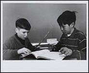 [Two student working on a class exercise with a notebook and ruler] [between 1900-1976]