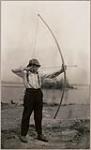 [Anishinaabe man Michel Finlayson drawing bow] [ca. 1916]