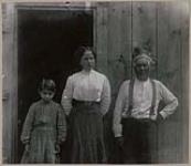 [Seth Newhouse and his two daughters in front of the entrance door of a house] 1912