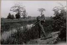 [John Jamieson Jr. fishing with a spear] 1912