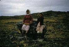 [Inuuk girls sitting on a rock] 1956