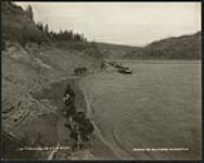[Hudson's Bay Company men tracking boats on Athabasca River.]. Original title: Tracking on Athabaska River [ca. 1901].