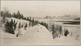 [John Voisey building an Iglu (snow house)] [between 1921-1922]