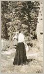 [Anishinaabe woman with baby in a tartan cloth tikinagan on her back] 1919
