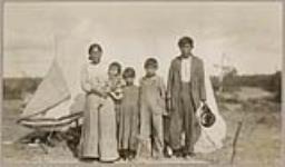[Anishinaabe family standing in front of a tent] 1920