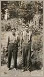 [Two young Anishinaabe men standing outside, wearing beaded moccasins] 1920