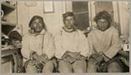 [Three Innu men seated inside a house, identified from left to right: Pukwee; Steamash (chief); Peéiwin] [between 1921-1922]