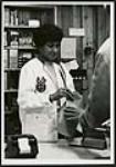 [Unidentified woman serving a customer at the counter of a store] [ca. 1970-1980]