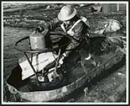 [Man on hovercraft pulling logs] [ca. 1960-1970]