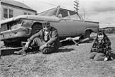 [[Jack and Cindy Paul sit near a car, Mi'kmaq Reserve, Millbrook] [ca. 1969].