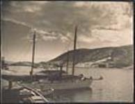 [Newfoundland fishing schooner with view of harbour] [ca. 1930].