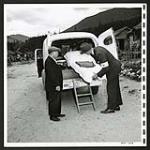 At the Lemon Creek Settlement, Mr. E. L. Maag, delegate in Canada for the International Committee of the Red Cross, inspects amulance equipment used [1945/06/16-1945/06/28]