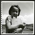 A little Japanese girl poses with the inevitable utensils of the school-room--scribblers, pencil box, ink, ruler [1945/06/16-1945/06/28]