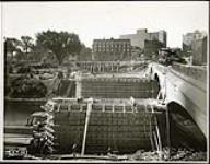 [Workers construct wooden frames for Plaza Bridge arches, Elgin Street in background] September 8, 1938