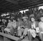 Seated in colored section, Jackie Robinson is visited by Lt. Bernard Jeffries, noted All-American gridder 20 April 1946.