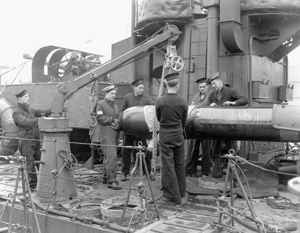 Naval ratings unloading a tropedo before the refit of an unidentified Town-class destroyer of the Royal Canadian Navy, Halifax, Nova Scotia, Canada, March 1941.