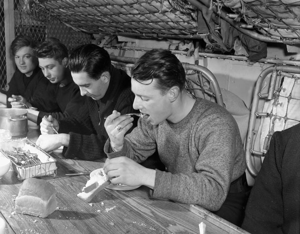 Unidentified ratings eating a meal aboard H.M.C.S ST CROIX at sea, March 1941.