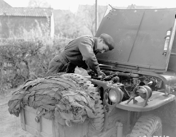 Private W.E. Lynch cleaning the engine of a jeep of the 1st Canadian Parachute Battalion, Luthe, Germany, 9 April 1945.