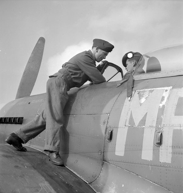 F/O C.J. MacGillivray explaining cockpit of Hawker 'Typhoon' IB aircraft of No.121 Squadron,  Royal Air Force (R.A.F.) to Lieut. W.C. Pearson, Antwerp, Belgium, 22 September 1944.
