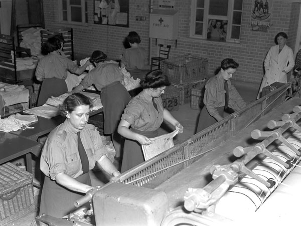 Personnel of the Canadian Women's Army Corps (C.W.A.C.) operating pressing machines at the Surrey County Council Central Laundry, Carshalton, England, 19 August 1943.