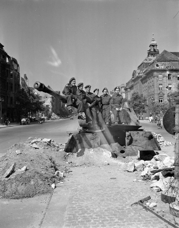 Personnel of the Canadian Berlin Battalion sitting on a dug-in German tank, Berlin, Germany, 14 July 1945.