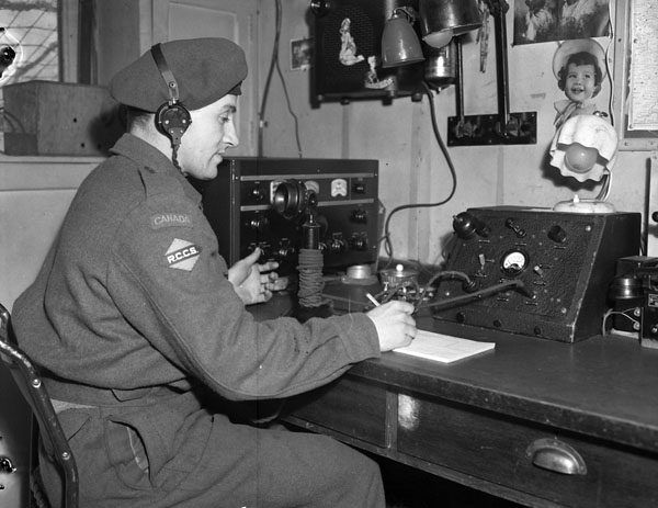 Signalman J.T. Prime of 1st Canadian Army Signals, Royal Canadian Corps of Signals (R.C.C.S.), operating a local radio receiver and remote unit, Zeddam, Netherlands, 4 April 1945.
