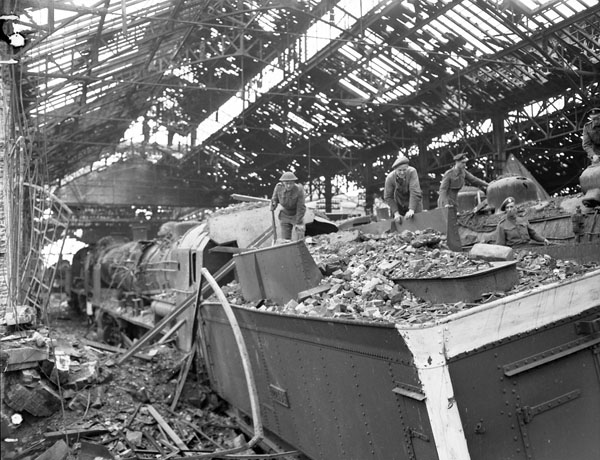 Personnel of No.1 Railway Workshop Company, Royal Canadian Engineers (R.C.E.), examining damaged rail  cars, Vaucelles, France, 23 July 1944.